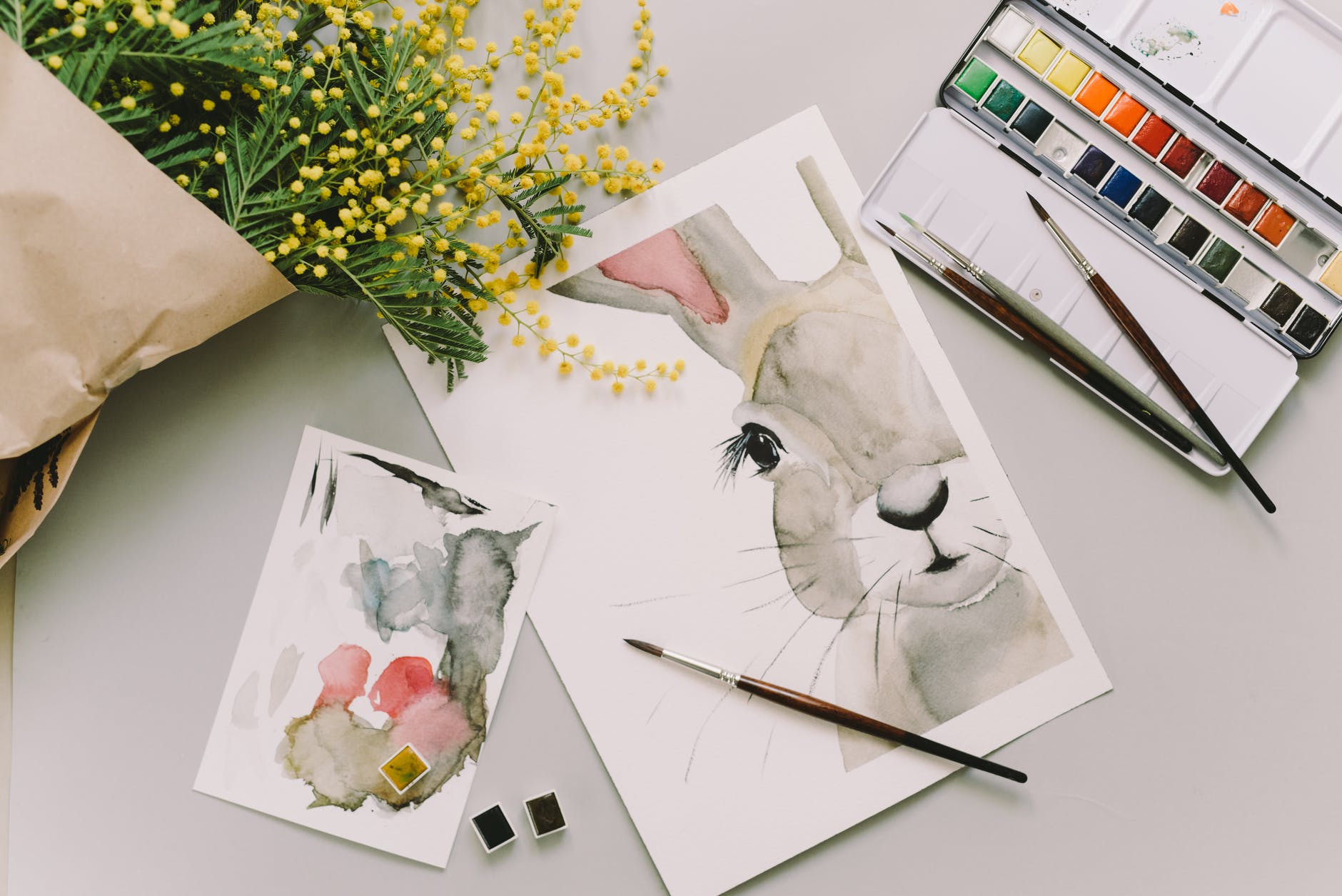 easter bunny painting and watercolor palette on white surface